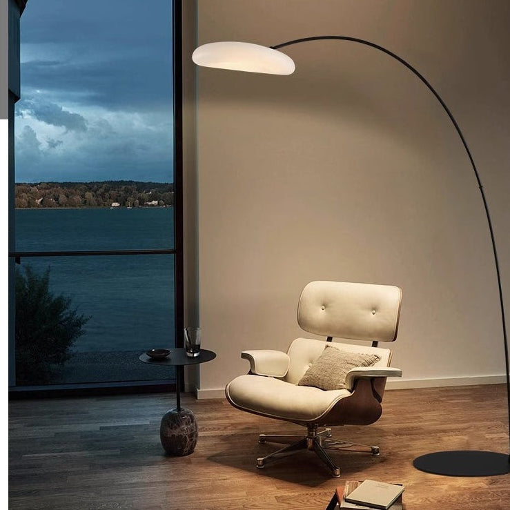 Nova LED Bogenlampe neben Loungesessel am Abend